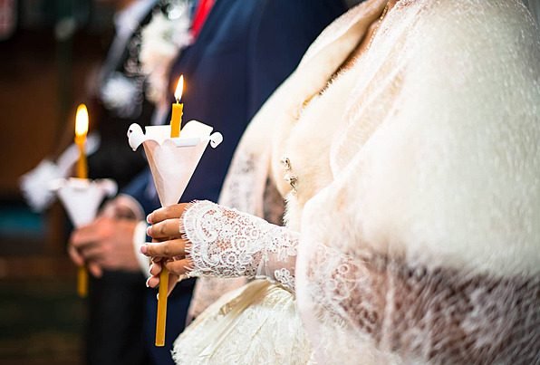 Bride holding a lit candle during the wedding ceremony