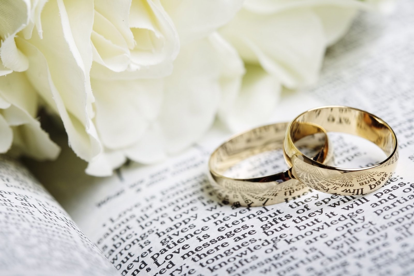 Wedding rings resting on an open Bible