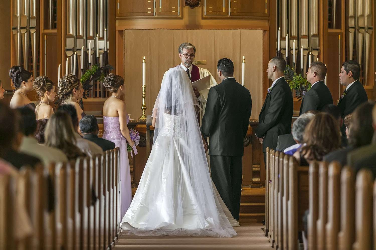 Bride and groom before the priest at the altar